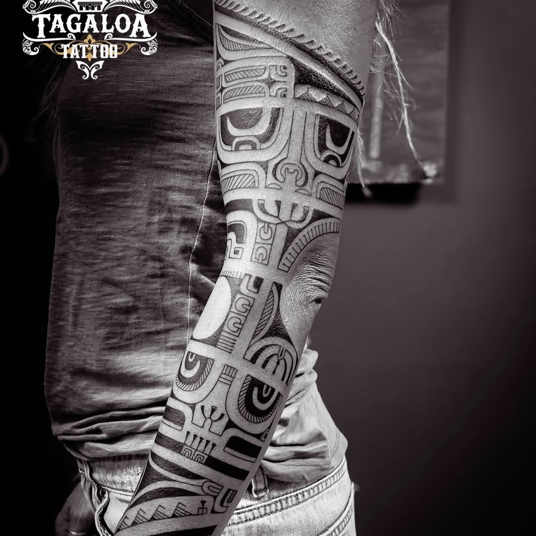 Bras tatoué en style marquisien géométrique